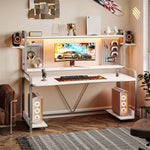 Load image into Gallery viewer, White LED gaming desk in a warm lit room with a monitor, speakers and shelving

